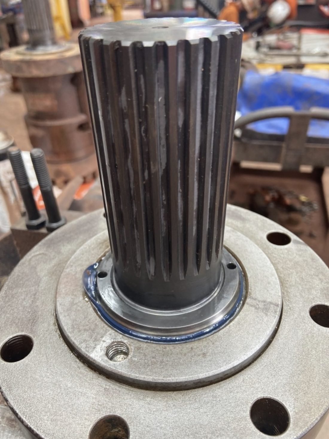 Refurbished splined drive shaft mounted to a machined flange on the workshop bench