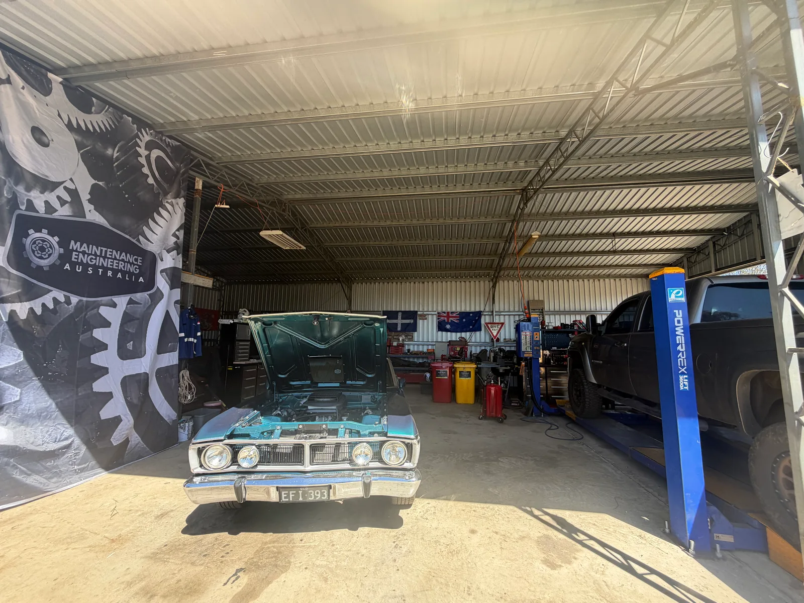 Falcon GT and a ute on the hoist in the Quinalow workshop