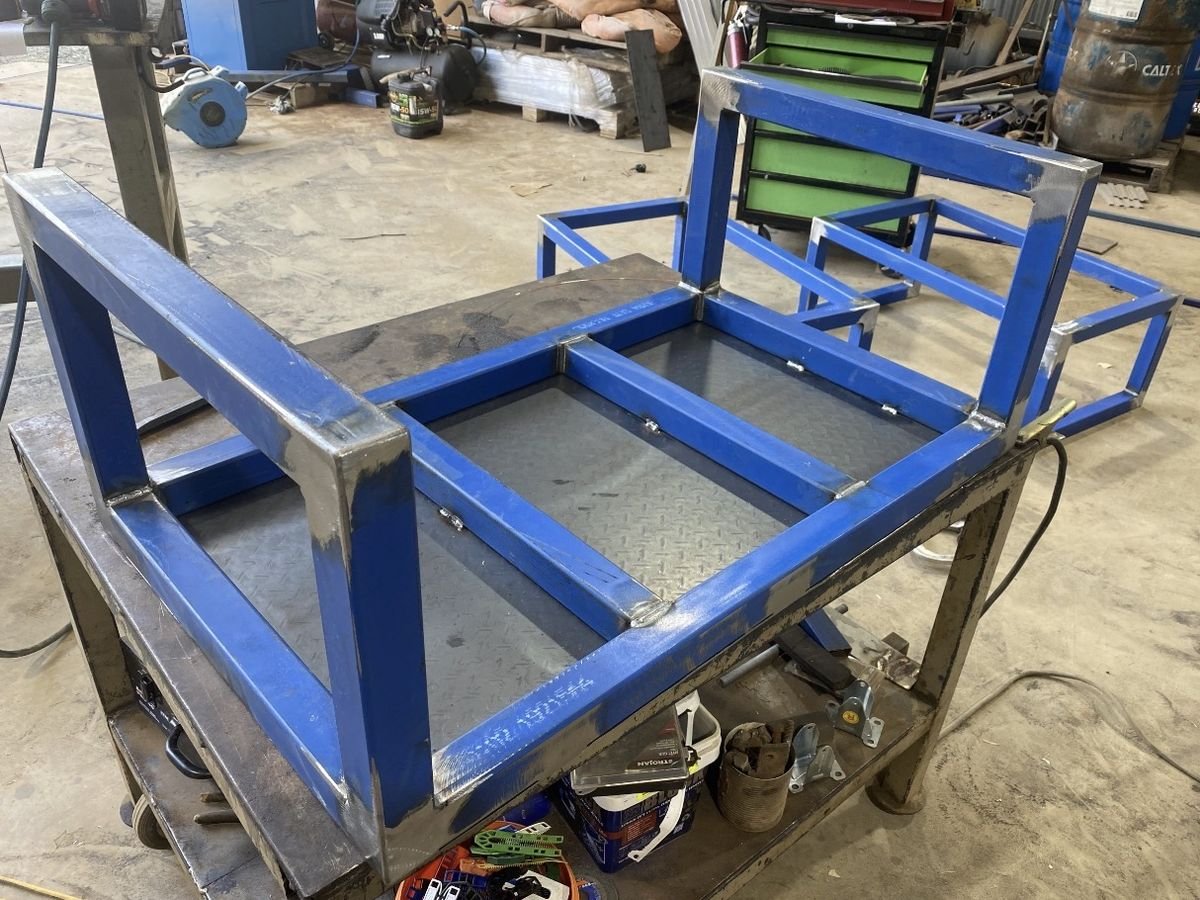 Fabricated steel frame under construction on a workshop bench