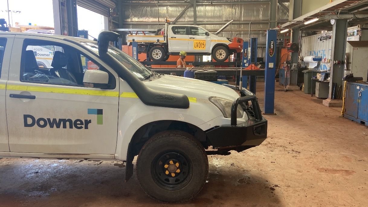 Service workshop with a light vehicle raised on a two post hoist and a field service ute in the foreground